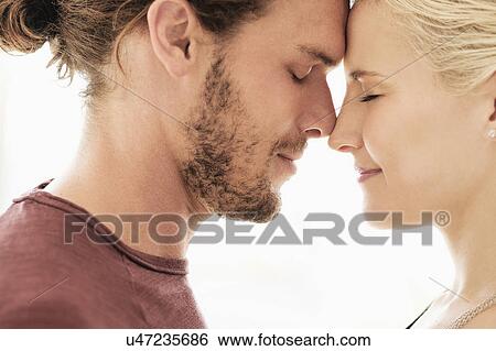 Couple rubbing noses on white background View Large Photo Image Stock Photograph - Couple rubbing noses on white background. Fotosearch