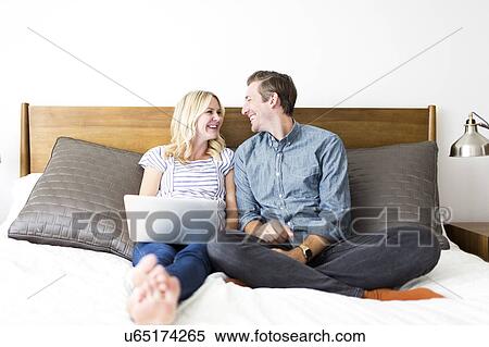 Couple sitting on bed View Large Photo Image Stock Photography - Couple sitting on bed. Fotosearch