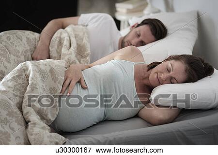 Stock Photo - Couple sleeping in bed. Fotosearch