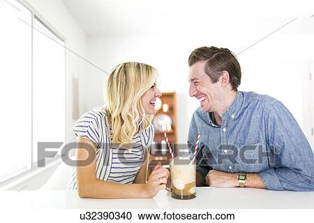 Stock Image - Couple spending time at home and drinking beer. Fotosearch