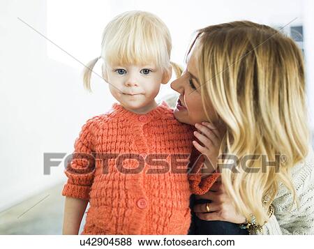 Stock Photo - Cute girl (2-3) looking at camera with mother. Fotosearch