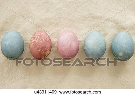Stock Photo - Dyed Easter eggs in a row on beige. Fotosearch