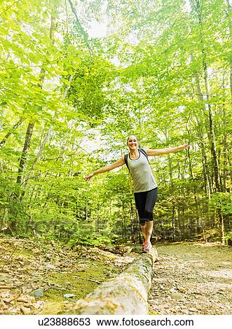Female hiker walking along log in forest View Large Photo Image Stock Image - Female hiker walking along log in forest. Fotosearch