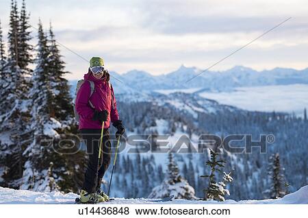 Stock Photo - Female skier against mountains. Fotosearch