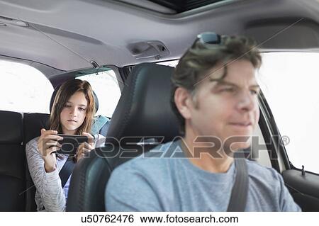 Girl (10-11) texting in back seat View Large Photo Image Stock Photograph - Girl (10-11) texting in back seat. Fotosearch