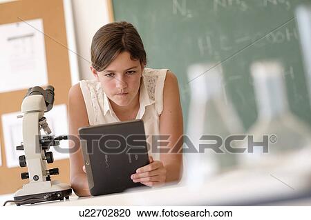 Stock Image - Girl (10-11) using tablet pc in classroom. Fotosearch
