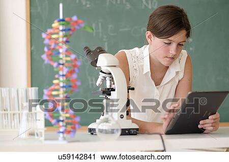 Stock Image - Girl (10-11) using tablet pc in classroom. Fotosearch