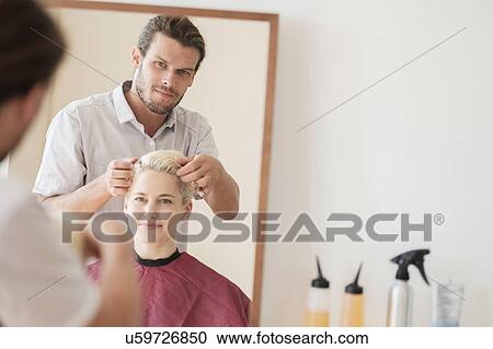 Hairdresser combing woman's hair View Large Photo Image Stock Image - Hairdresser combing woman's hair. Fotosearch