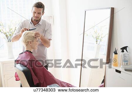Hairdresser combing woman's hair View Large Photo Image Stock Image - Hairdresser combing woman's hair. Fotosearch