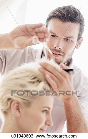 Stock Image - Hairdresser cutting woman's hair. Fotosearch