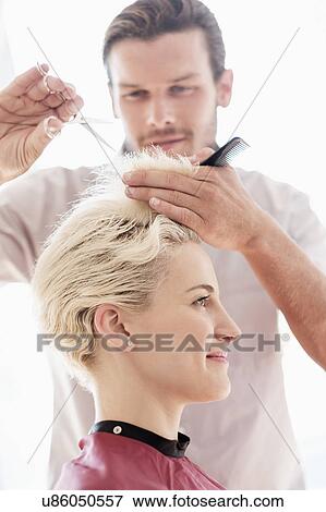 Stock Photo - Hairdresser cutting woman's hair. Fotosearch