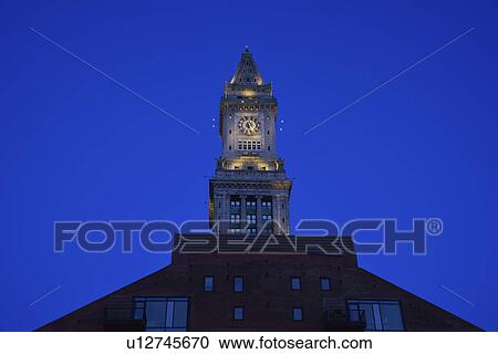 Stock Image - Illuminated clock tower at dawn. Fotosearch