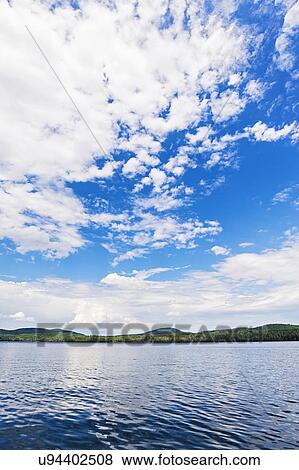Lake under blue sky with clouds View Large Photo Image Stock Photo - Lake under blue sky with clouds. Fotosearch