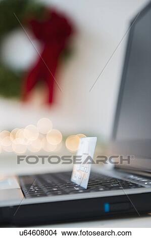 Picture - Laptop with credit card and Christmas decoration in background. Fotosearch