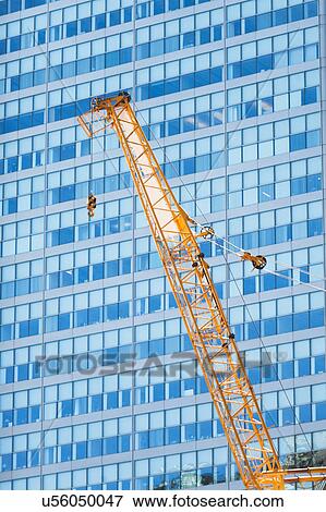 Low angle view of crane against skyscraper View Large Photo Image Stock Photo - Low angle view of crane against skyscraper. Fotosearch