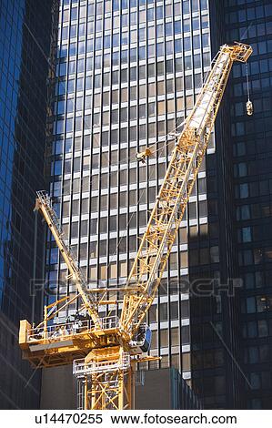 Stock Photography - Low angle view of crane against skyscraper. Fotosearch