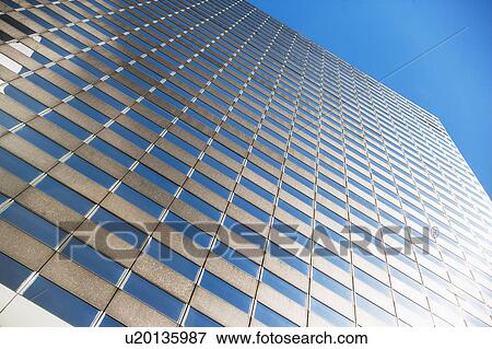 Stock Photo - Low angle view of skyscraper against blue sky. Fotosearch