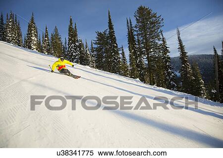 Low angle view of young man on ski slope View Large Photo Image Stock Photography - Low angle view of young man on ski slope. Fotosearch