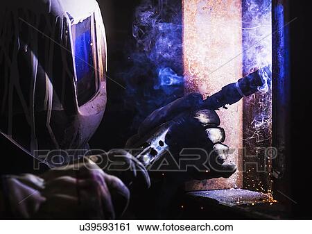 Stock Image - Man in welding mask working. Fotosearch