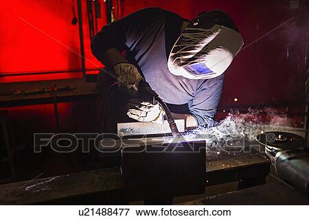 Stock Photo - Man in welding mask working. Fotosearch
