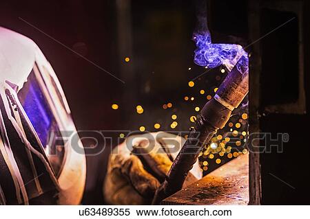 Man in welding mask working View Large Photo Image Stock Photography - Man in welding mask working. Fotosearch