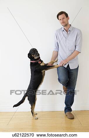 Stock Image - Man playing with dog. Fotosearch