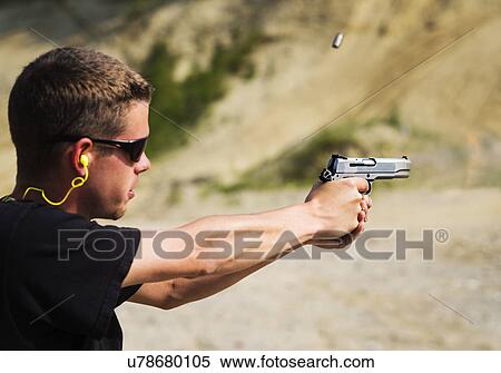 Stock Photography - Man shooting handgun. Fotosearch