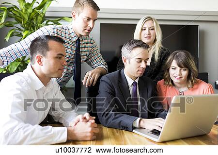 Stock Image - Man showing presentation on laptop. Fotosearch