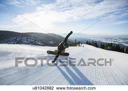 Stock Image - Man snowboarding downhill. Fotosearch