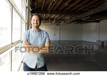 Man standing by window in warehouse View Large Photo Image Stock Photograph - Man standing by window in warehouse. Fotosearch