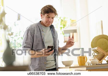 Man texting and eating View Large Photo Image Stock Image - Man texting and eating. Fotosearch