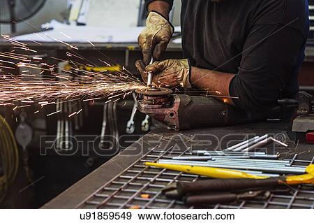 Stock Photo - Man using circular saw in workshop. Fotosearch