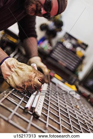 Stock Image - Man using ruler in workshop. Fotosearch