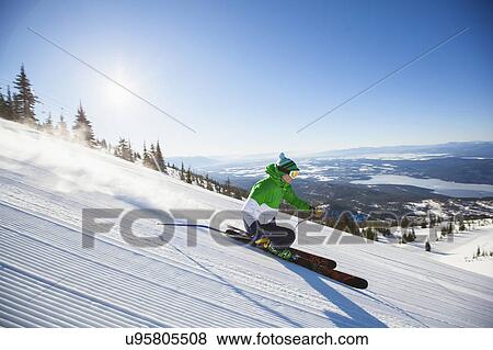 Stock Photo - Mature man on ski slope at sunlight. Fotosearch