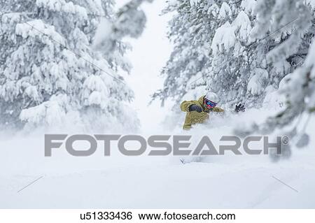 Stock Photograph - Mature man on ski slope at sunset. Fotosearch