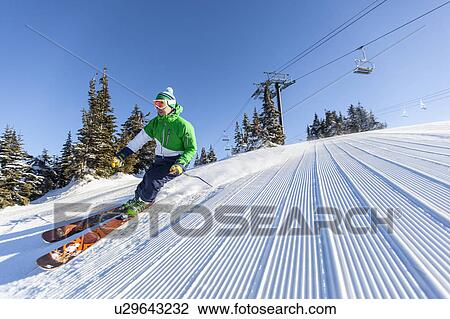 Mature man on ski slope under blue sky View Large Photo Image Stock Image - Mature man on ski slope under blue sky. Fotosearch