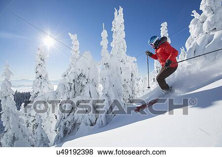 Stock Photo - Mature woman on ski slope at sunlight. Fotosearch
