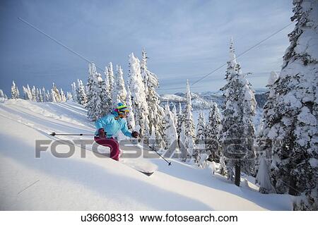 Stock Image - Mature woman speeding on ski slope. Fotosearch