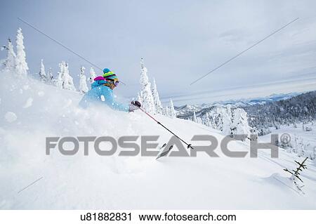 Stock Image - Mature woman speeding on ski slope. Fotosearch