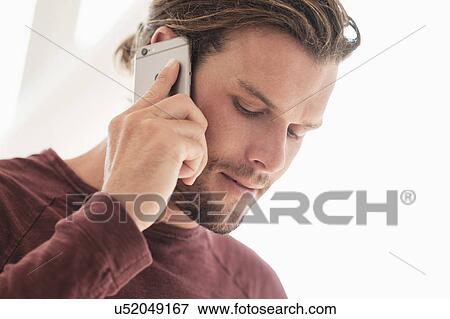 Stock Photo - Mid-adult man talking on phone. Fotosearch