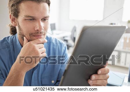 Mid-adult man using tablet pc View Large Photo Image Stock Photography - Mid-adult man using tablet pc. Fotosearch