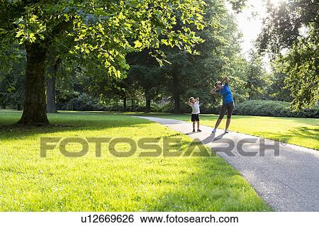 Mother and son (12-13) exercising in park View Large Photo Image Stock Photograph - Mother and son (12-13) exercising in park. Fotosearch