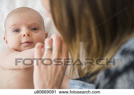 Stock Image - Mother consoling baby girl (2-5 months). Fotosearch