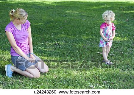 Stock Image - Mother copying daughter's (4-5) facial expression. Fotosearch
