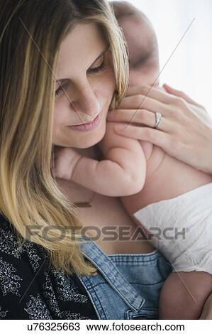 Mother holding baby girl (2-5 months) in her arms View Large Photo Image Stock Image - Mother holding baby girl (2-5 months) in her arms. Fotosearch