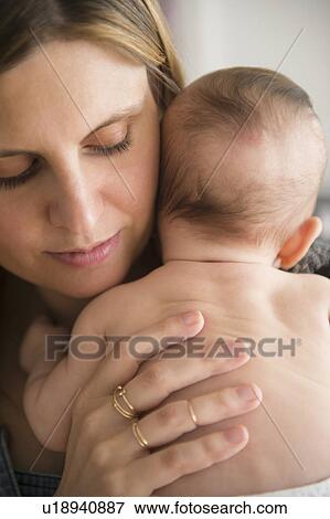 Mother holding baby girl (2-5 months) in her arms View Large Photo Image Stock Photo - Mother holding baby girl (2-5 months) in her arms. Fotosearch