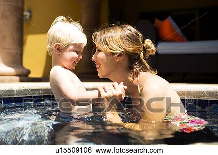 Stock Photograph - Mother with son (2-3) in swimming pool. Fotosearch