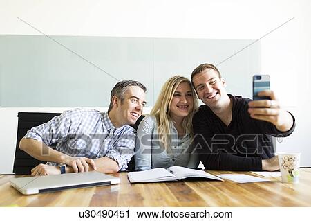Office workers taking selfie View Large Photo Image Stock Image - Office workers taking selfie. Fotosearch
