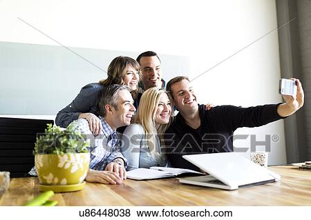 Office workers taking selfie View Large Photo Image Stock Photo - Office workers taking selfie. Fotosearch