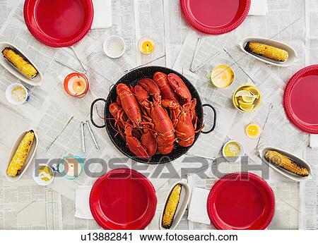 Stock Image - Plate with lobsters on dining table. Fotosearch